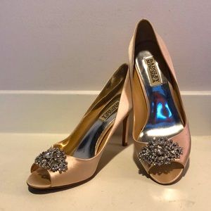 Badgley Mischka blush peep toe satin pumps with crystal embellishment.
